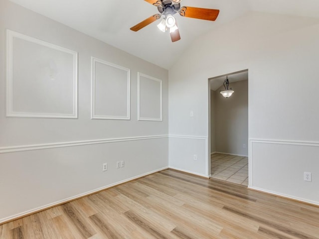 empty room featuring ceiling fan, lofted ceiling, and light hardwood / wood-style floors