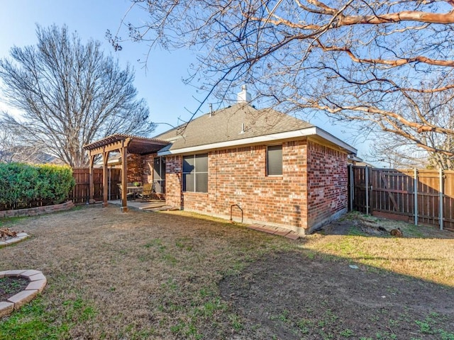 rear view of property with a yard and a pergola