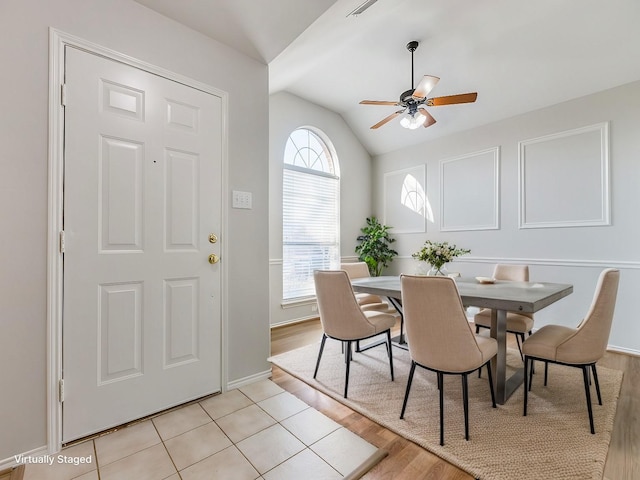 dining area with lofted ceiling, ceiling fan, and light wood-type flooring