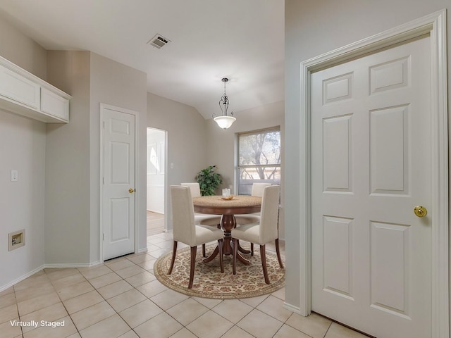 tiled dining room with lofted ceiling