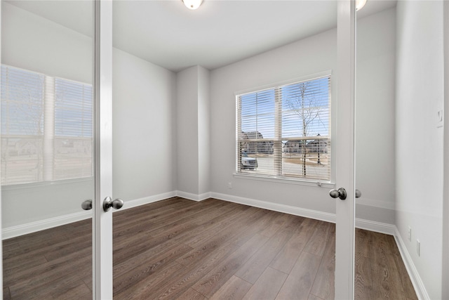 spare room featuring dark hardwood / wood-style floors and french doors