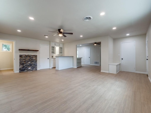 unfurnished living room featuring ceiling fan and light wood-type flooring