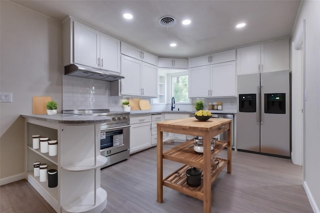 kitchen with white cabinetry, sink, backsplash, and stainless steel appliances