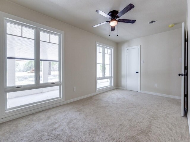 carpeted spare room with ceiling fan