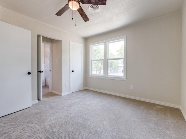 unfurnished bedroom featuring light carpet, sink, ceiling fan, and ensuite bathroom