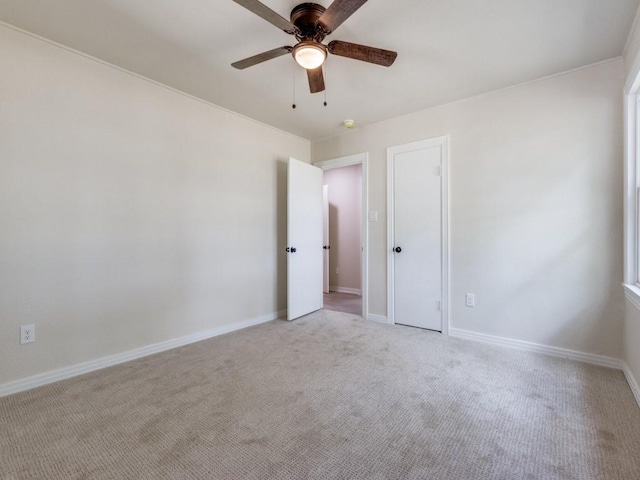 carpeted spare room with ceiling fan