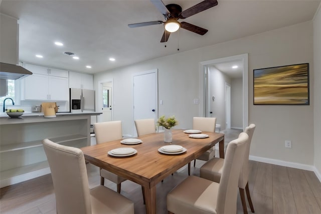 dining room with sink, ceiling fan, and light wood-type flooring