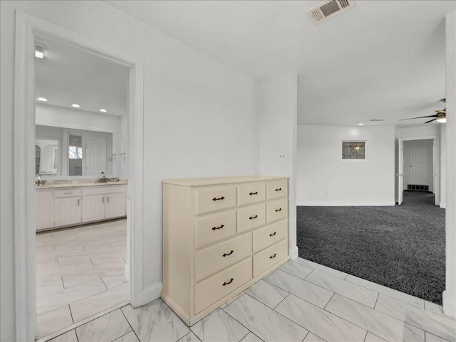 carpeted spare room with ceiling fan and sink