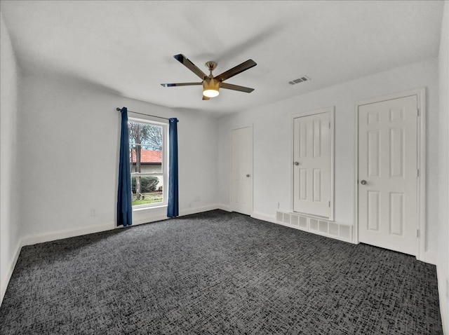 unfurnished room featuring dark carpet and ceiling fan