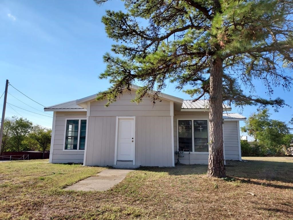 rear view of property featuring a yard