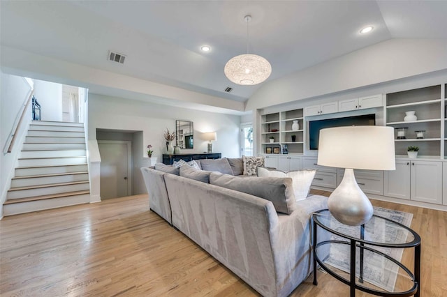 living room featuring lofted ceiling and light hardwood / wood-style floors