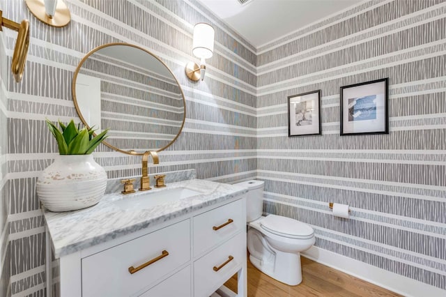 bathroom with hardwood / wood-style flooring, vanity, and toilet