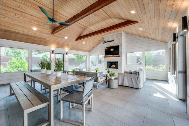 sunroom / solarium featuring ceiling fan, a wealth of natural light, lofted ceiling with beams, and wooden ceiling