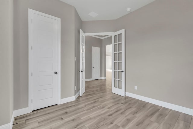 unfurnished room with light wood-type flooring and french doors