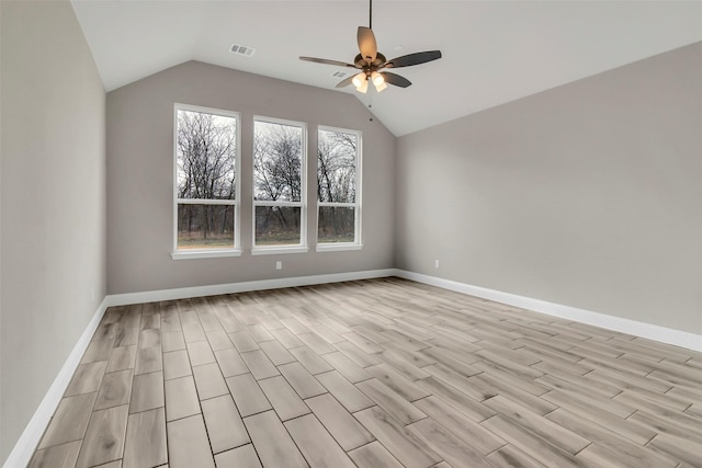 empty room with ceiling fan, light hardwood / wood-style floors, and vaulted ceiling