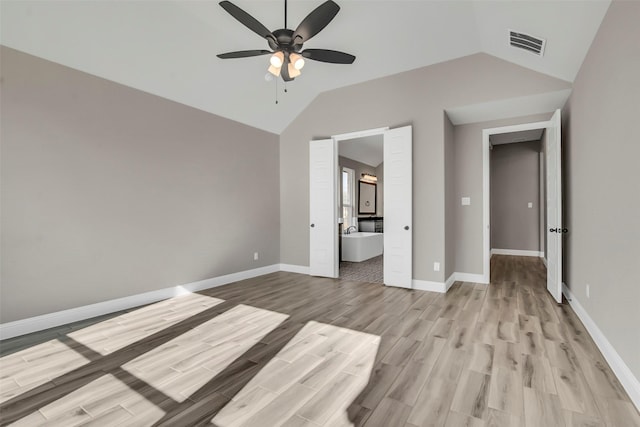 unfurnished bedroom featuring ceiling fan, ensuite bath, lofted ceiling, and light hardwood / wood-style floors