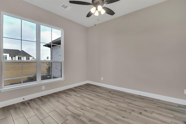 spare room featuring ceiling fan, light hardwood / wood-style floors, and a wealth of natural light