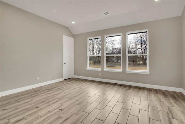 unfurnished room with vaulted ceiling and light hardwood / wood-style floors