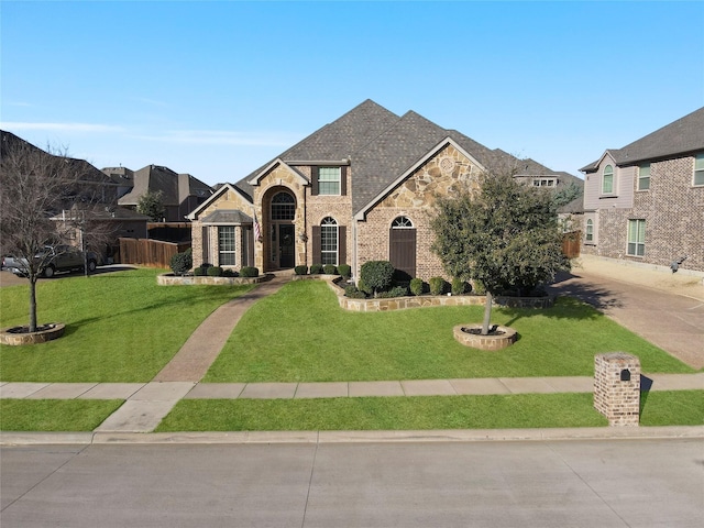 view of front of house featuring a front yard, stone siding, and brick siding