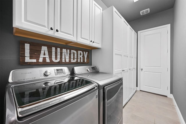 laundry area featuring cabinet space, baseboards, visible vents, washer and clothes dryer, and light tile patterned flooring