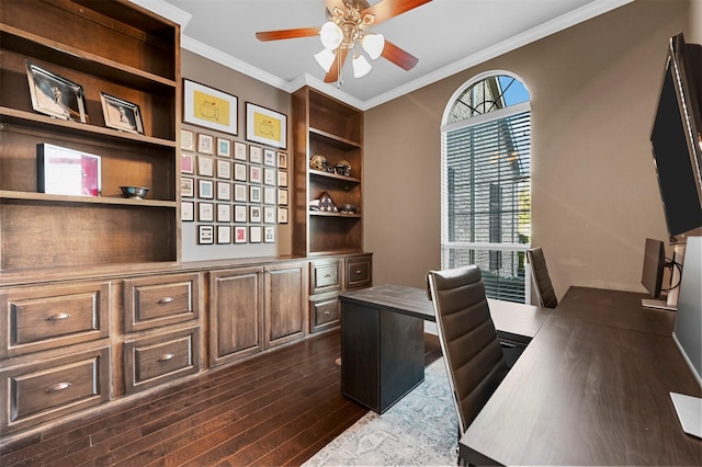 office space featuring built in shelves, a ceiling fan, dark wood finished floors, and crown molding