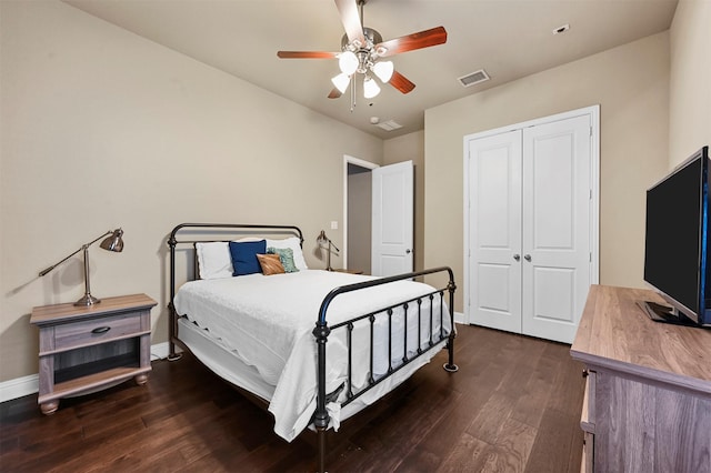 bedroom featuring baseboards, visible vents, a ceiling fan, wood finished floors, and a closet