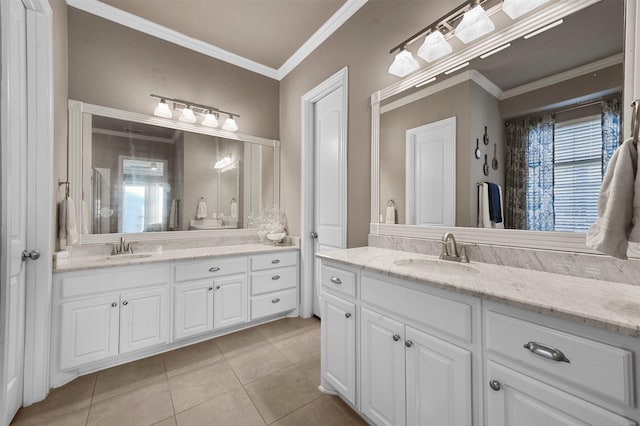 bathroom featuring ornamental molding, two vanities, and a sink