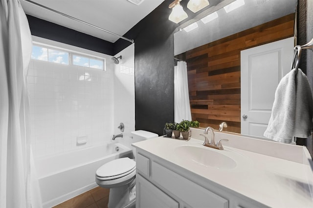 full bathroom with toilet, shower / bath combo, wood walls, vanity, and tile patterned flooring