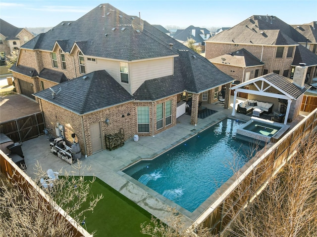 view of pool featuring a pool with connected hot tub, a fenced backyard, a patio, and an outdoor living space