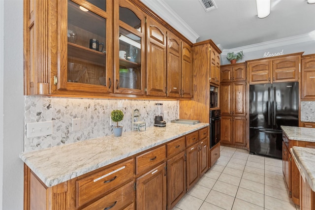 kitchen with tasteful backsplash, light tile patterned floors, ornamental molding, light stone countertops, and black appliances