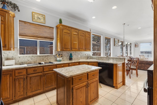 kitchen with decorative light fixtures, a center island, sink, and black appliances