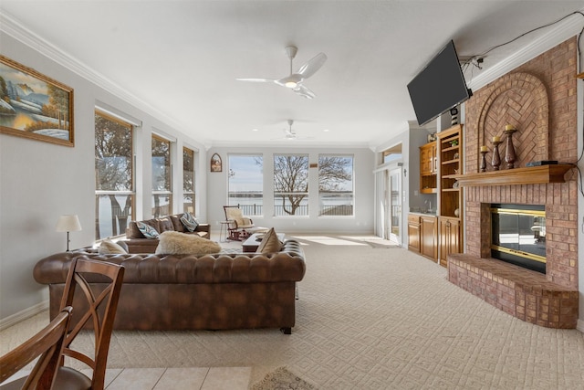 living room with crown molding, ceiling fan, a fireplace, and light carpet