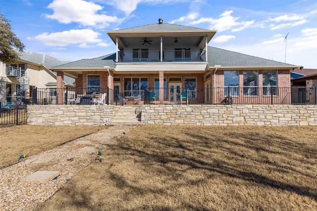 back of house with ceiling fan, a yard, and a balcony