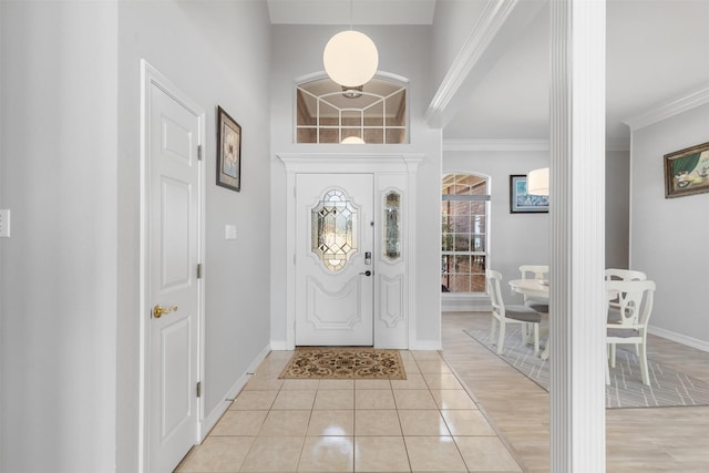 entrance foyer featuring light tile patterned floors and ornamental molding