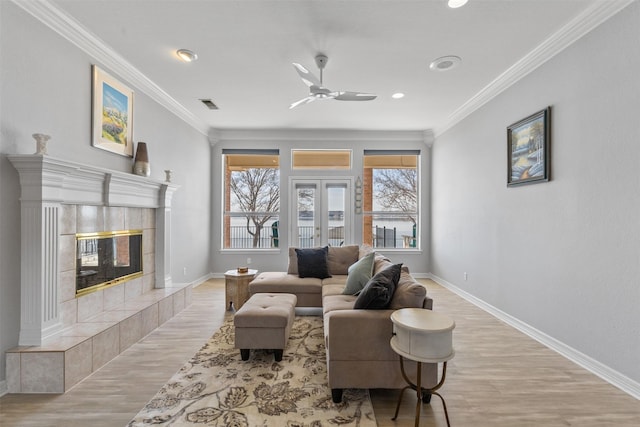 living room featuring ornamental molding, a fireplace, and plenty of natural light