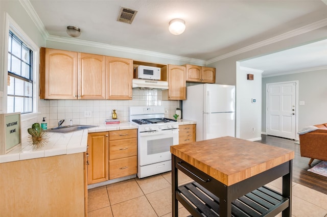 kitchen featuring light tile patterned flooring, tasteful backsplash, tile countertops, ornamental molding, and white appliances