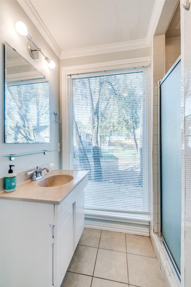 bathroom with tile patterned flooring, crown molding, vanity, and walk in shower