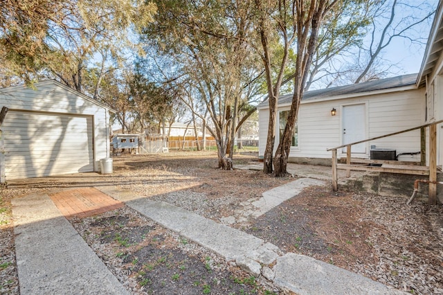 view of yard featuring a garage, an outdoor structure, and central AC