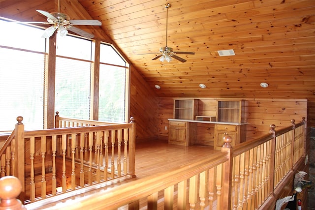 hallway with vaulted ceiling, light hardwood / wood-style flooring, wood ceiling, and wood walls