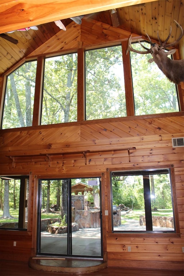 interior space featuring wooden walls and high vaulted ceiling