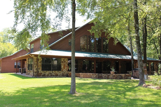 rear view of house with central AC unit and a yard