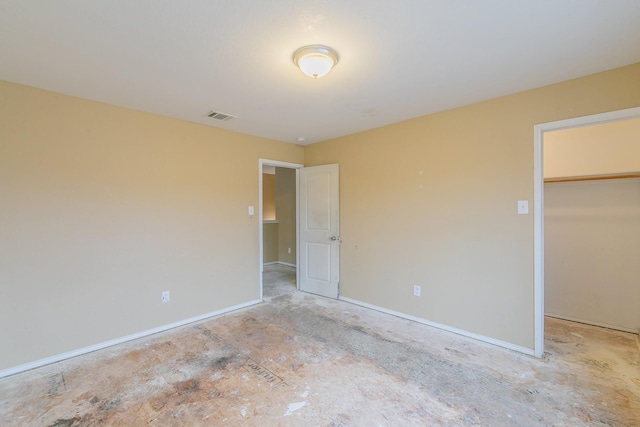 unfurnished bedroom featuring a spacious closet