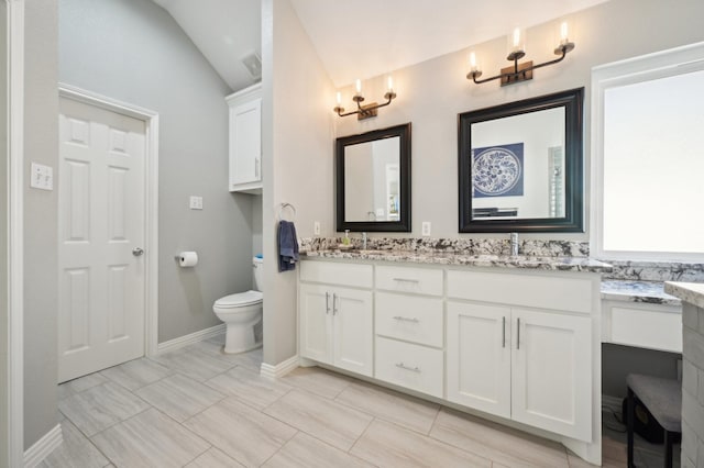 bathroom with lofted ceiling, vanity, and toilet