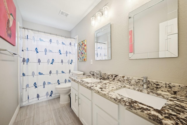 bathroom featuring vanity, curtained shower, and toilet