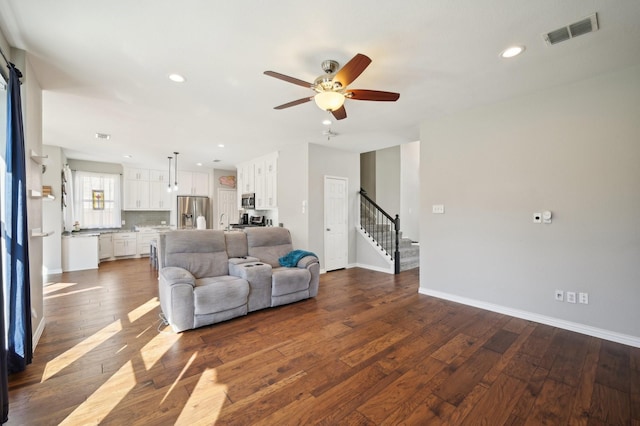 living room featuring ceiling fan and dark hardwood / wood-style flooring