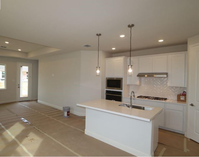 kitchen with a kitchen island with sink, decorative light fixtures, decorative backsplash, and white cabinets