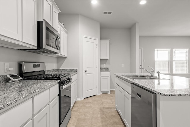 kitchen with white cabinetry, sink, stainless steel appliances, and an island with sink