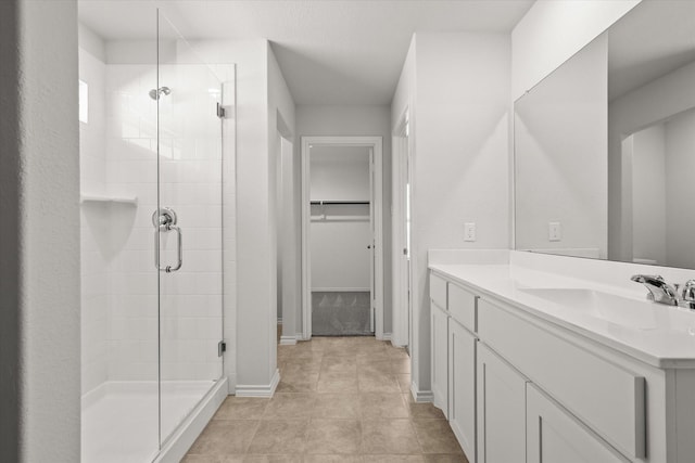 bathroom with vanity, a shower with shower door, and tile patterned floors