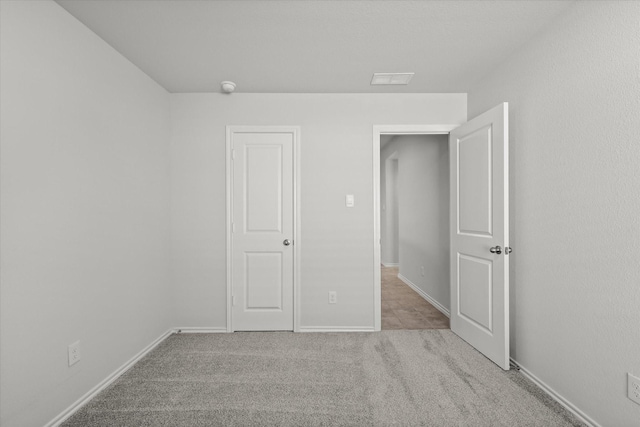 unfurnished bedroom featuring light carpet