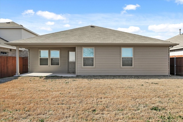 rear view of house featuring a yard and a patio